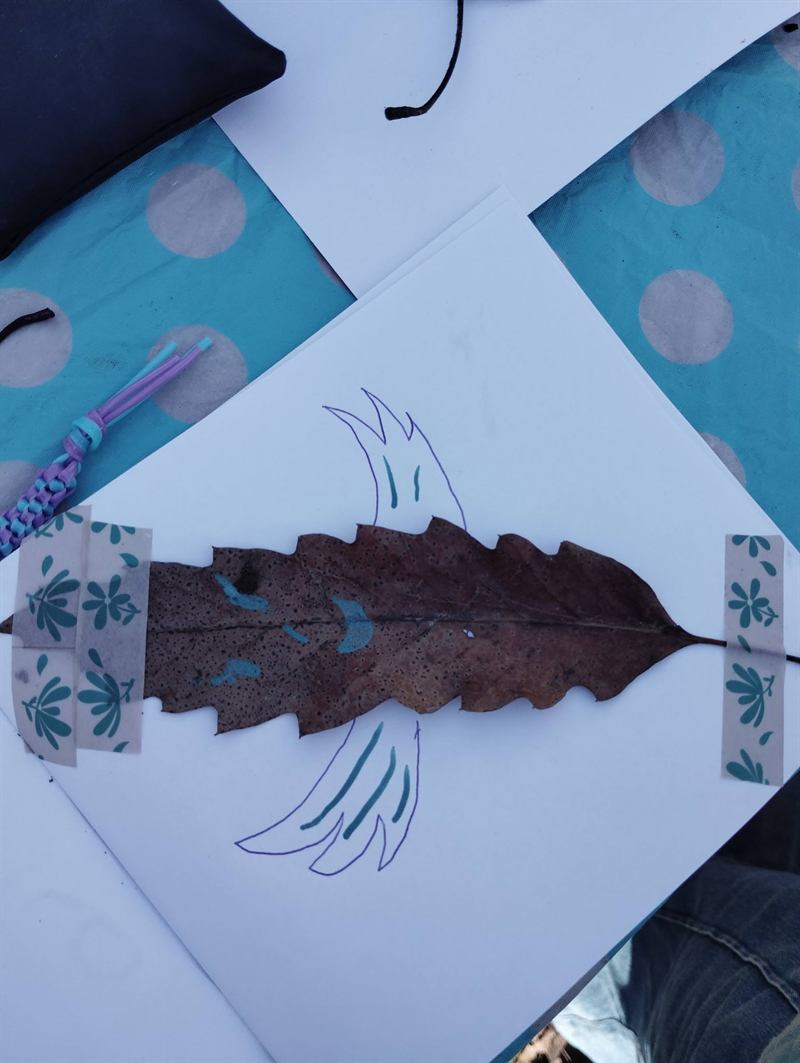 Création land art : un oiseau dessiné prolongé par une feuille